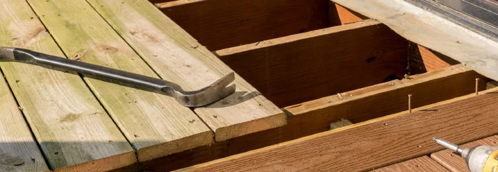 Holzterrasse wird mit Brecheisen repariert